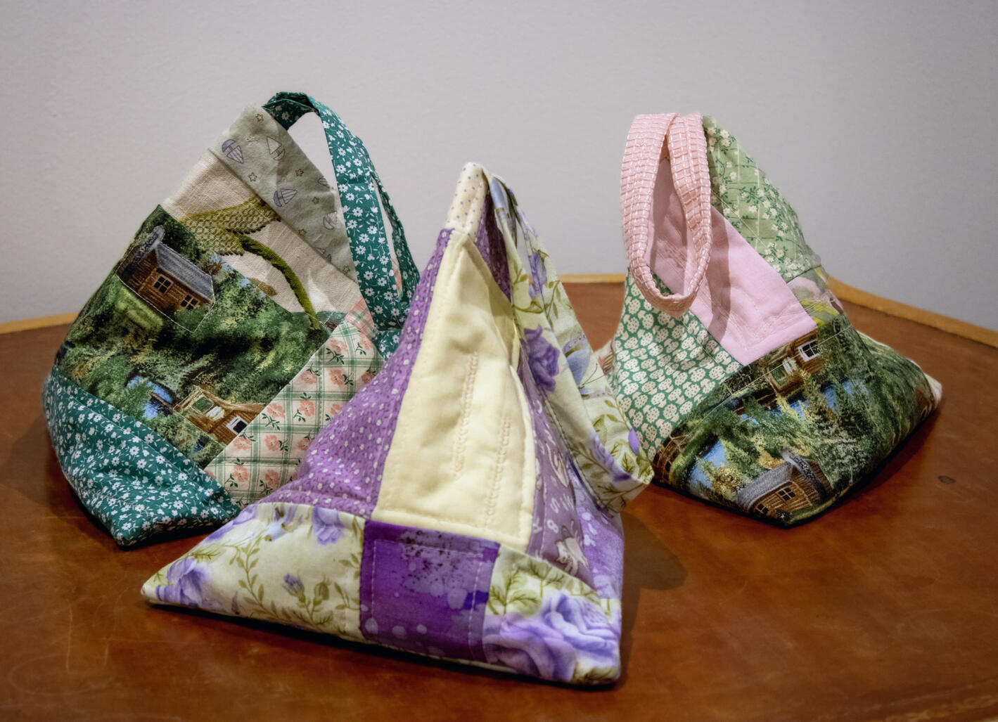 Sound holder (multiple), 2022, quilted bag with handle, found objects, 10" x 10" x 10" (each)